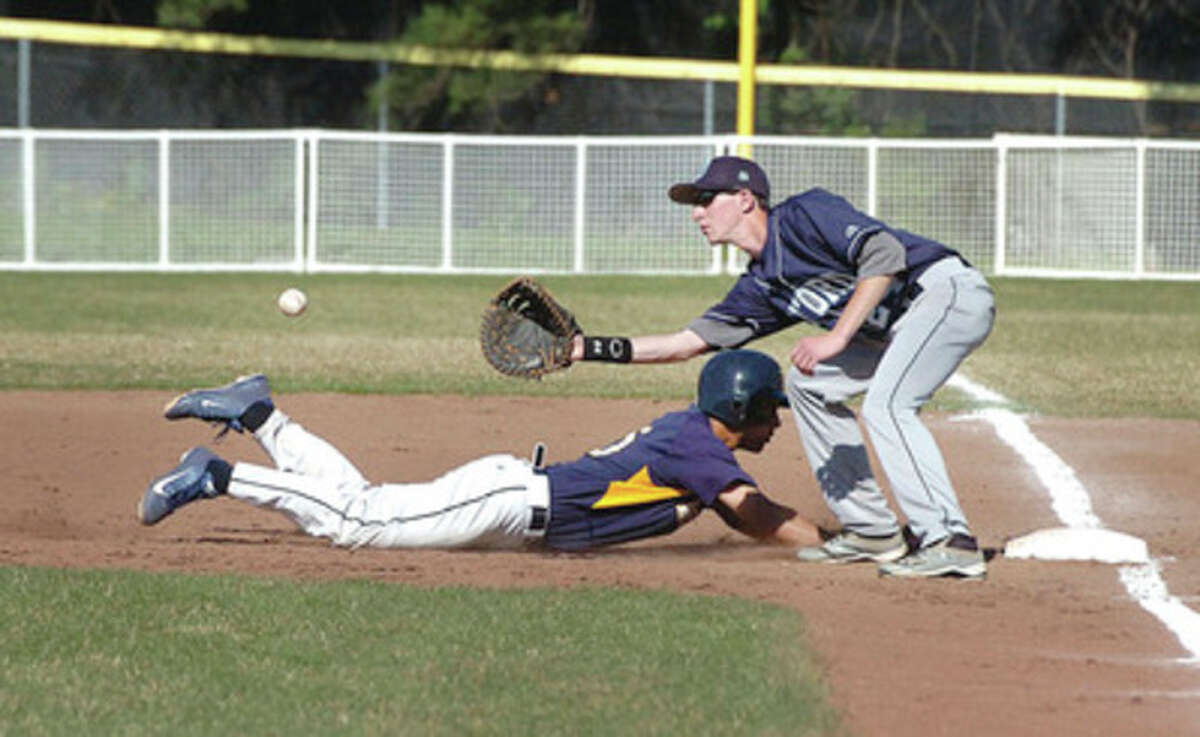 Hour photo/Alex von Kleydorff Weston's Asher Lee-Tyson dives back into first on a pickoff attempt during Thursday's game against Oxford at Weston's Revson Field. First baseman J.P. DeFrancesco takes the throw. Trailing 7-1 in the second inning, the Trojans roared back to claim a 9-8 victory.