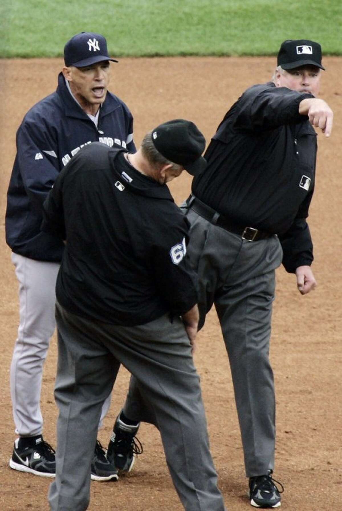 New York Yankees manager Joe Girardi, left, is tossed by third base umpire Tim Welke, right, after arguing about a double by Detroit Tigers' Andy Dirks that hit down the left field line in the fifth inning of a baseball game, Thursday, Aug. 9, 2012, in Detroit. Welke first signaled a foul ball and then signaled a fair ball on the play. Second base umpire Bob Davidson, front, looks on. (AP Photo/Duane Burleson)