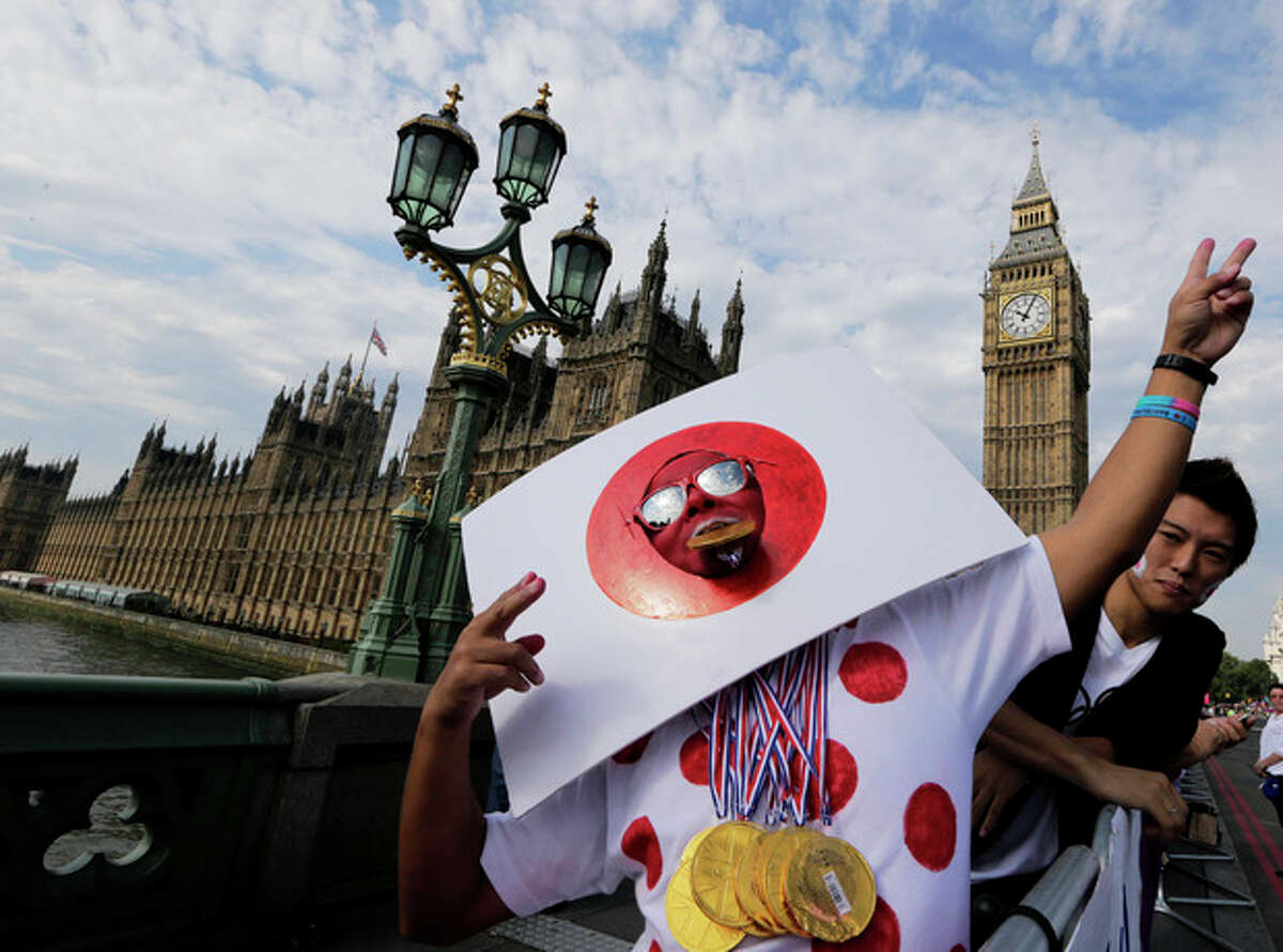 A Japanese supporter gestures near Big Ben and the Houses of Parliament, prior to the start of the men's marathon at the 2012 Summer Olympics, at the 2012 Summer Olympics, London, Sunday, Aug. 12, 2012. (AP Photo/Luca Bruno)