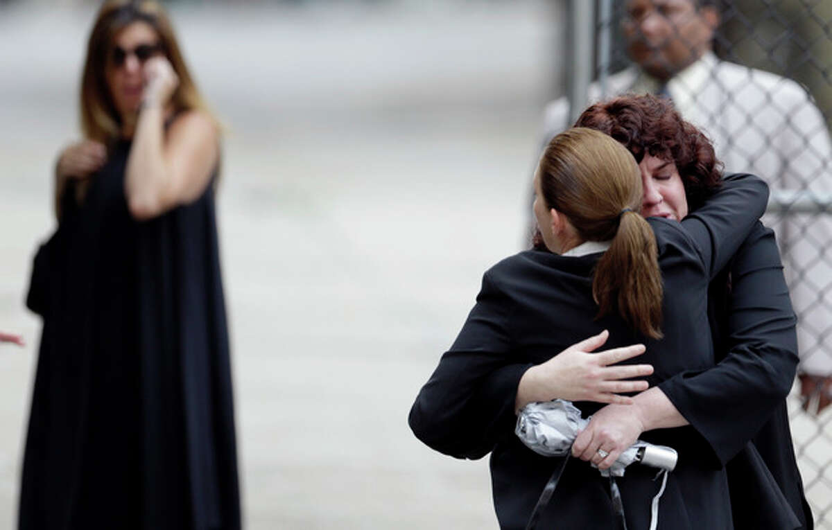 Women embrace outside of Cathedral Church of Saint John the Divine before funeral services actor James Gandolfini, Thursday, June 27, 2013, in New York. Gandolfini, who played Tony Soprano in the HBO show "The Sopranos", died while vacationing in Italy last week. (AP Photo/Julio Cortez)