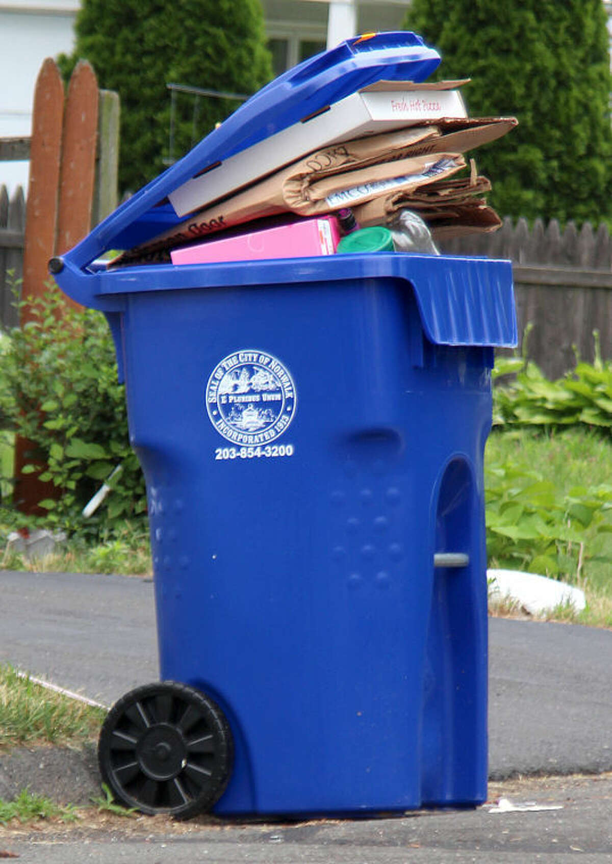 Hour photo / Chris Bosak Monday was the first day for single-stream recycling in Norwalk. Streets in the Spring Hill area of the city were lined with both the new arge blue recycling bins as well as the old smaller bins.