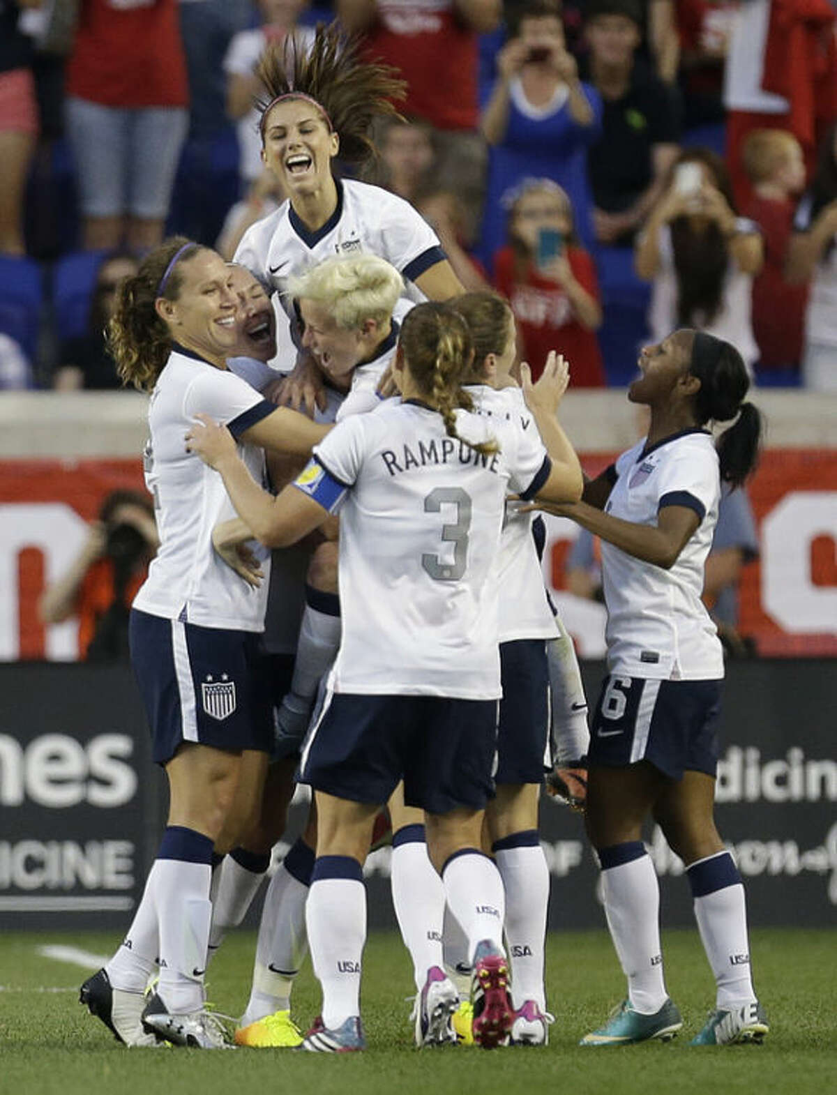 United States women soccer players mob Abby Wambach after she scored a goal against South Korea during the first half of an international friendly soccer match at Red Bull Arena, Thursday, June 20, 2013, in Harrison, N.J. With the goal, Wambach broke Mia Hamm's national goal-scoring record. (AP Photo/Julio Cortez)