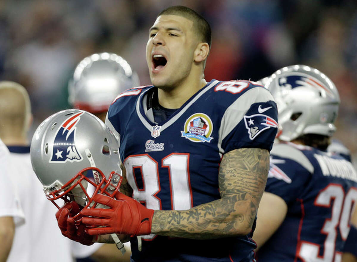 FILE - In this Dec. 10, 2012 file photo, New England Patriots tight end Aaron Hernandez reacts during the second quarter of an NFL football game against the Houston Texans in Foxborough, Mass. State and local police spent hours at the home of New England Patriots tight end Aaron Hernandez on Tuesday June 18, 2013 as another group of officers searched an industrial park about a mile away where a body was discovered the day before. (AP Photo/Elise Amendola, File)