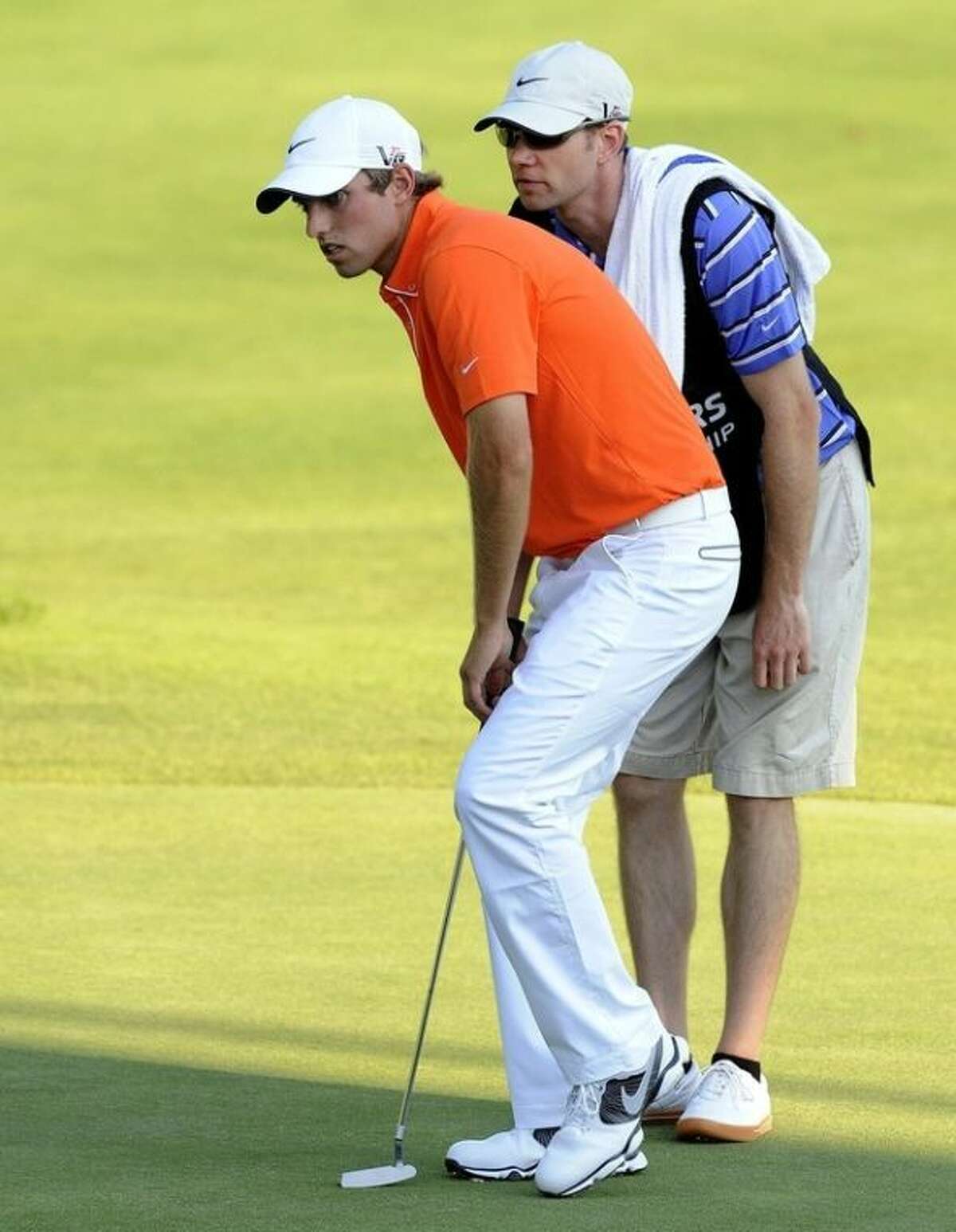 Chris Williams, left, reads a putt with his caddie on the 18th hole of his first professional tournament during the first round of the Travelers Championship golf tournament in Cromwell, Conn., Thursday, June 20, 2013. (AP Photo/Fred Beckham)