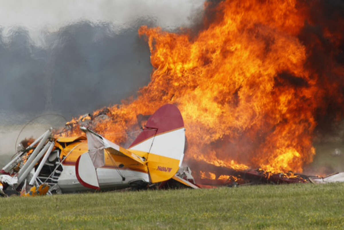 Flames erupt from a plane after it crashed at the Vectren Air Show at the airport in Dayton, Ohio. The crash killed the pilot and stunt walker on the plane instantly, authorities said. (AP Photo/Dayton Daily News, Ty Greenlees)