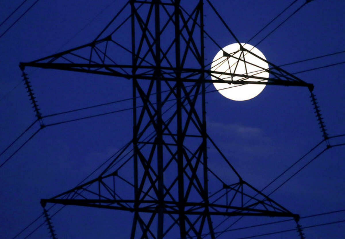 The moon rises behind power lines on Saturday, June 22, 2013, in Nashville, Tenn. The biggest and brightest full moon of the year, called a supermoon, happens as the moon passes closer to earth than usual. (AP Photo/Mark Humphrey)