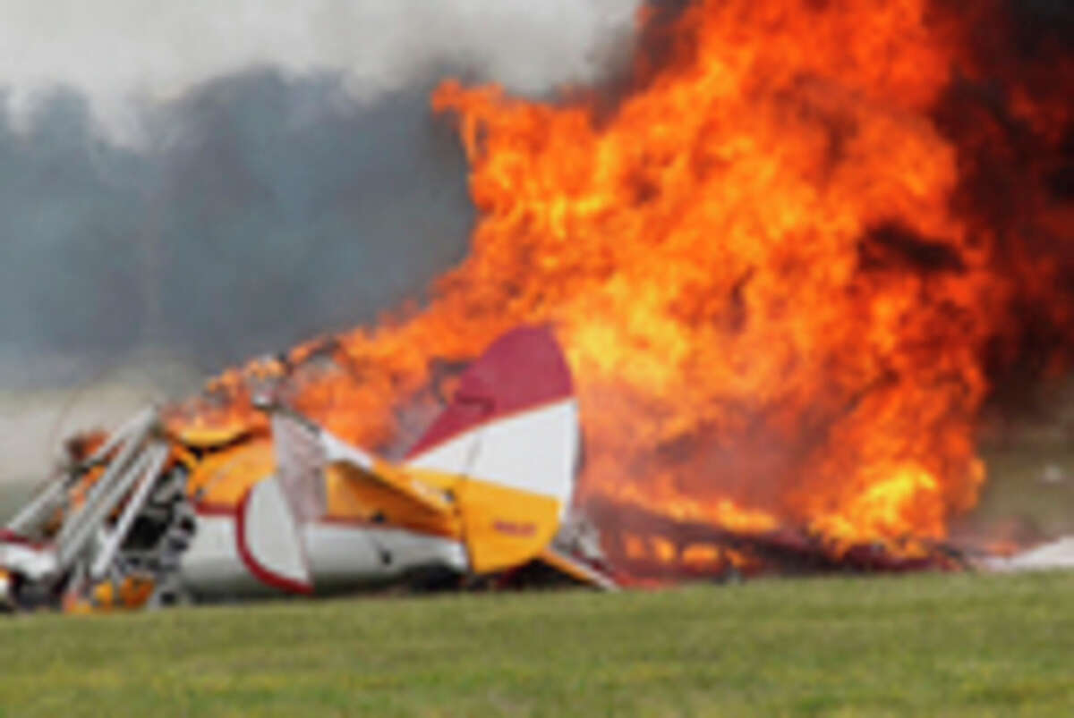 Flames erupt from a plane after it crashed at the Vectren Air Show at the airport in Dayton, Ohio, on Saturday, June 22, 2013. The crash killed the pilot and stunt walker on the plane instantly, authorities said. (AP Photo/Dayton Daily News, Ty Greenlees)