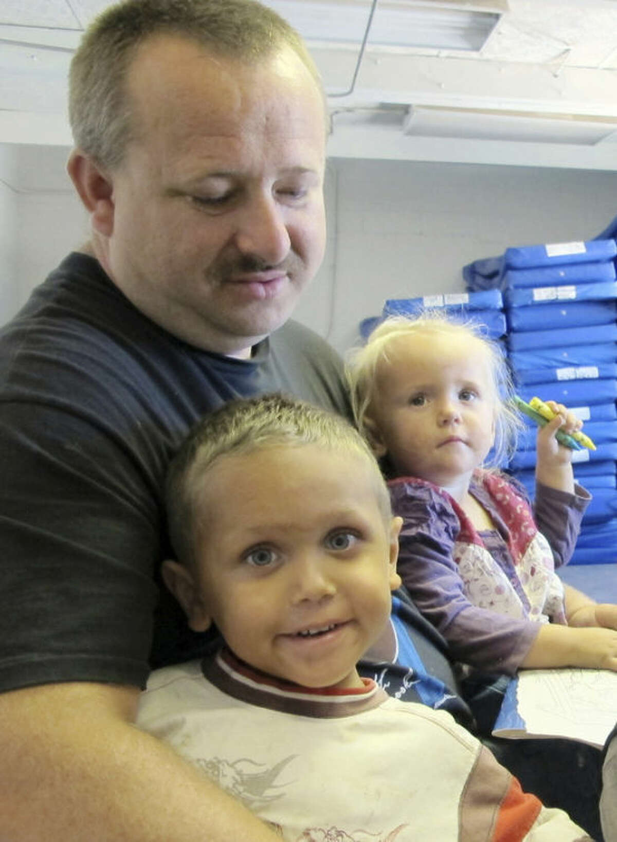 This June 20, 2013 image shows William Roper holding his 4-year-old son William Jr. and 2-year-old daughter Kacie during an interview at Joy Junction homeless shelter in Albuquerque, N.M. A report released by the Annie E. Casey Foundation shows the number of children living in poverty increased to 23 percent in 2011. The survey ranks New Mexico as the worst in the nation when it comes to child well-being. (AP Photo/Susan Montoya Bryan)