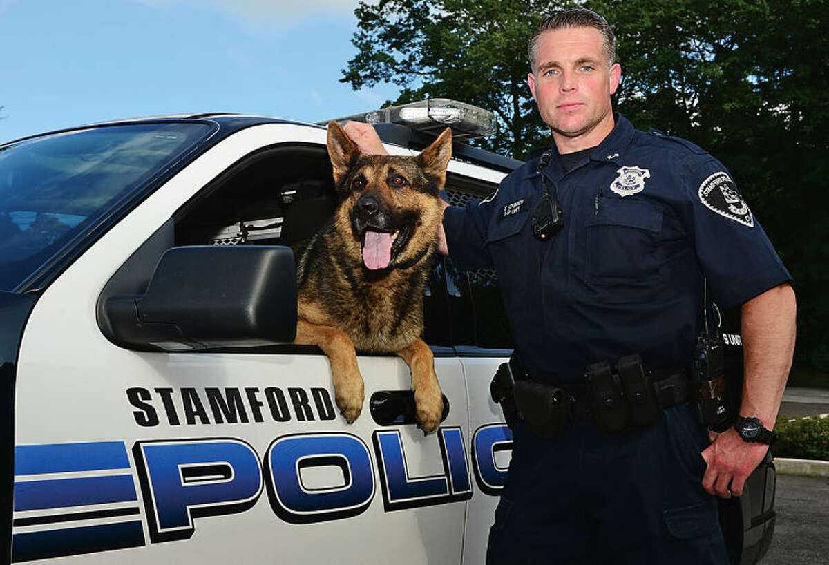 Stamford Officer of the Year Seth O’Brien stands alongside police service dog Cooper. O’Brien was instrumental in relaunching the department’s K-9 unit several years ago.
