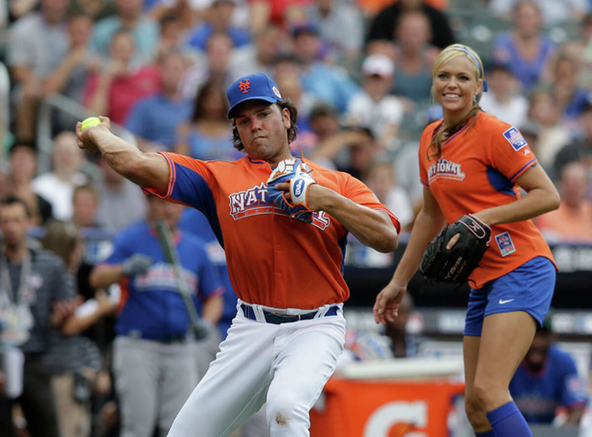 Former New York Mets catcher Mike Piazza makes a play during the All Star Legends & Celebrity Softball Game on Sunday, July 14, 2013 in New York. Former softball player Jennie Finch is at right. (AP Photo/Kathy Willens)
