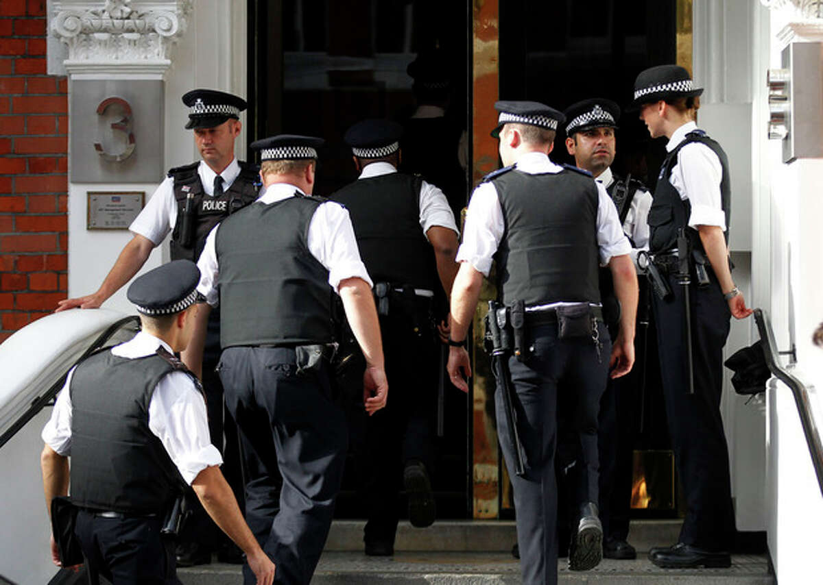 British police officers stand guard outside the Ecuadorian Embassy in central London, Thursday, Aug. 16, 2012. WikiLeaks founder Julian Assange entered the embassy in June in an attempt to gain political asylum to prevent him from being extradited to Sweden, where he faces allegations of sex crimes, which he denies. (AP Photo/Sang Tan)