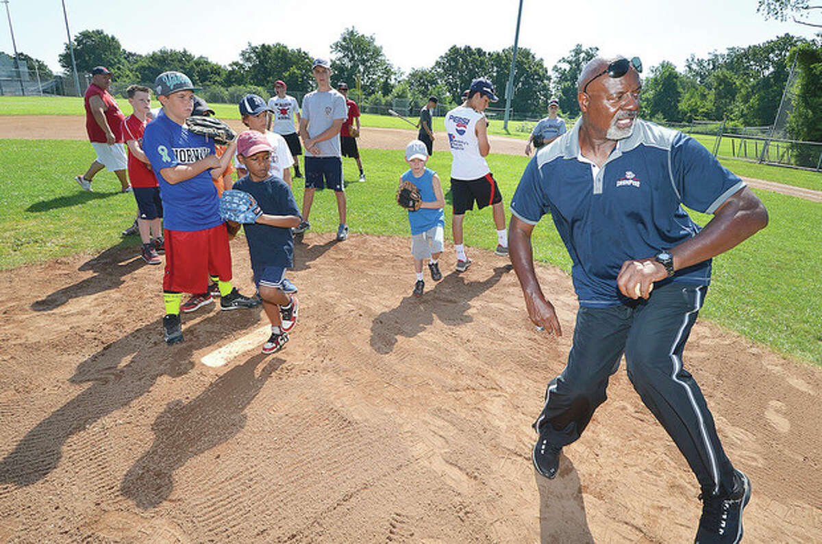 Hour Photo/Alex von Kleydorff Former Major League Baseball pitcher Ray Burris, right, who spent time with the Chicago Cubs as well as the New York Mets and Yankees, shows some techniques to become a better pitcher during a baseball camp at Brien McMahon High School