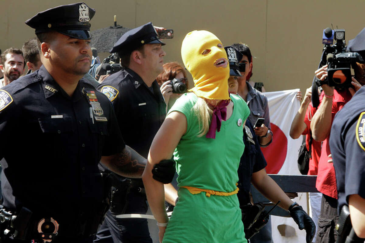 A protester is arrested during a demonstration in front of the Russian consulate in support of Russian punk band Pussy Riot, Friday, Aug. 17, 2012 in New York. A Russian judge found three members of the provocative punk band guilty of hooliganism on Friday, in one of the most closely watched cases in recent Russian history. The judge said the three band members committed hooliganism driven by religious hatred and offending religious believers. The three were arrested in March after a guerrilla performance in Moscow's main cathedral calling for the Virgin Mary to protect Russia against Vladimir Putin, who was elected to a new term as Russia's president a few days later. (AP Photo/Alex Katz)