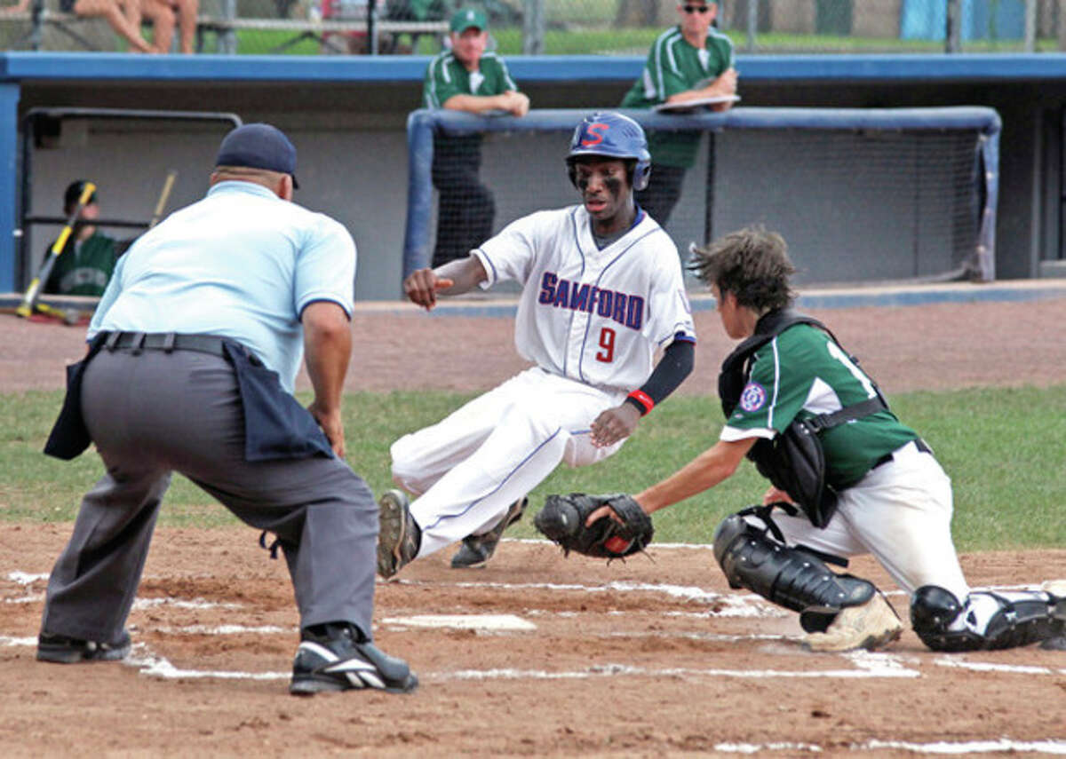 Photo by Danielle Calloway Stamford's Dave Lauture, center, slides into home during the Babe Ruth District 1 Championship game against Greenwich at Cubeta Field on Monday afternoon in Stamford. Stamford won, 3-2.