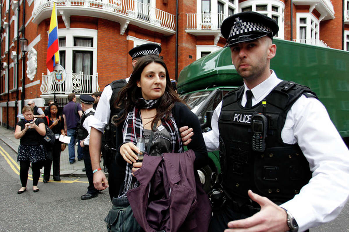British police officers move a protester in support of WikiLeaks founder Julian Assange from the front of Ecuadorian Embassy in central London, London, Thursday, Aug. 16, 2012. WikiLeaks founder Julian Assange entered the embassy in June in an attempt to gain political asylum to prevent him from being extradited to Sweden, where he faces allegations of sex crimes, which he denies. (AP Photo/Sang Tan)