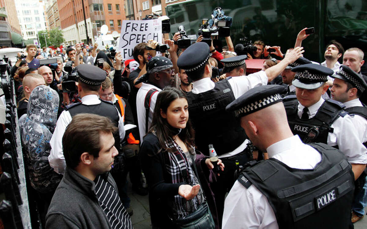 British police officers move the protesters in support of WikiLeaks founder Julian Assange from the front of the Ecuadorian Embassy in central London, London, Thursday, Aug. 16, 2012. WikiLeaks founder Julian Assange entered the embassy in June in an attempt to gain political asylum to prevent him from being extradited to Sweden, where he faces allegations of sex crimes, which he denies. (AP Photo/Sang Tan)