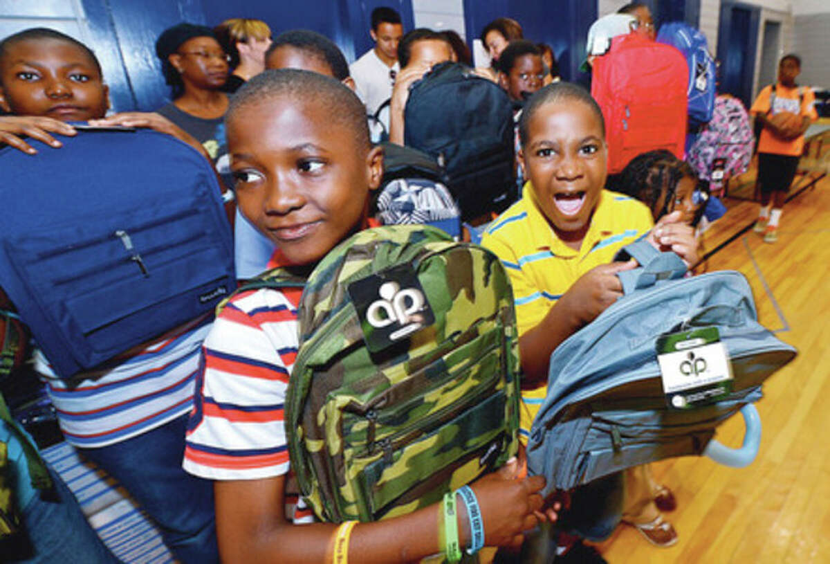 Redly Wolfe and Ramonce Charles gets free back packs from the New Beginnings Church during Roodner Court Family Day Saturday at Nathaniel Ely School. Hour photo / Erik Trautmann