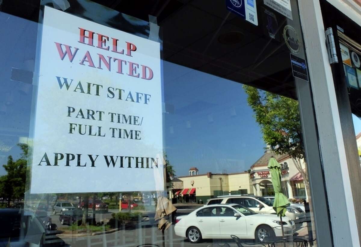 In this , Friday, June 21, 2013, photo, a Help Wanted sign is displayed in the window of a restaurant at a shopping center in Charlotte, N.C. The Labor Department reports on the number of Americans who applied for unemployment benefits last week on July 11, 2013. (AP Photo/Chuck Burton)