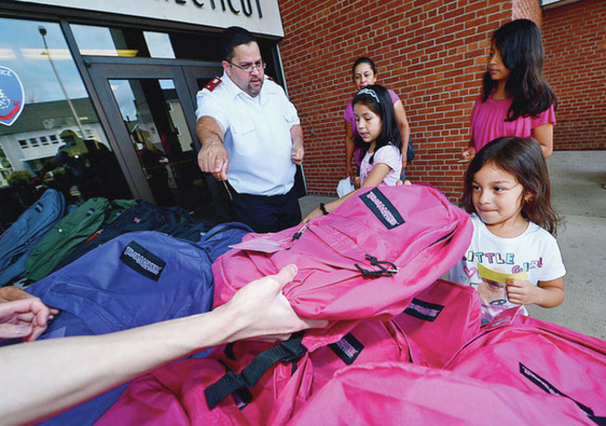 Some 500 Stamford schoolchildren including Rocio Rodriguez, 5, get school supplies and backpacks Saturday at the Stamford police station during the annual event sponsored by the Salvation Army and the Stamford Police Association. Hour photo / Erik Trautmann