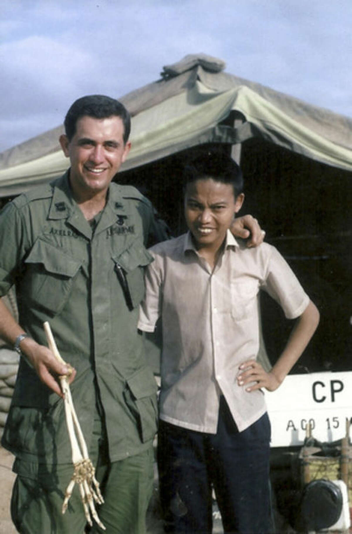 In this January 1967 photo released by Sam Axelrad, Dr. Sam Axelrad, left, displays the bones of an arm he amputated from North Vietnamese soldier Nguyen Quang Hung, right, in October 1966 in front of his military clinic in Phu Cat District in central coastal province of Binh Dinh in the former South Vietnam after Hung was shot by American troops near Hung's hometown of An Khe. On Monday, July 1, 2013 the Houston urologist met Hung at his home to return to bones. The two veterans were reunited after a Vietnamese journalist wrote an article last year about Axelrad's search for Hung, prompting Hung's brother to contact the newspaper. (AP Photo /Courtesy of Sam Axelrad)