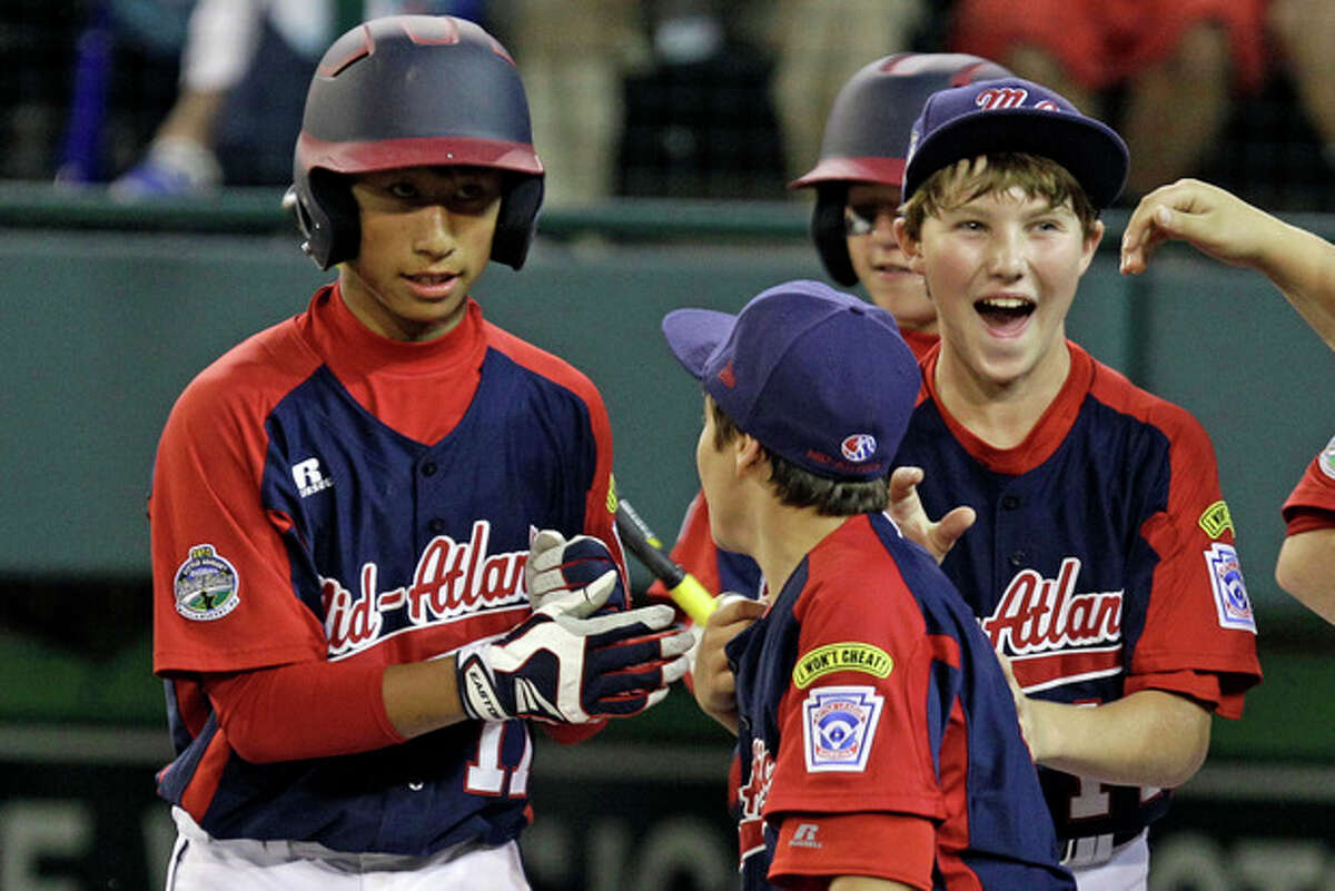 Parsippany, NJ.'s Emil Matti, left, is greeted by teammates after hitting a solo-home run off Gresham, Ore. pitcher Brett Falkner in the second inning of an elimination baseball game at the Little League World Series tournament in South Williamsport, Pa., Saturday, Aug. 18, 2012. It was Matti's second homer of the game. (AP Photo/Gene J. Puskar)