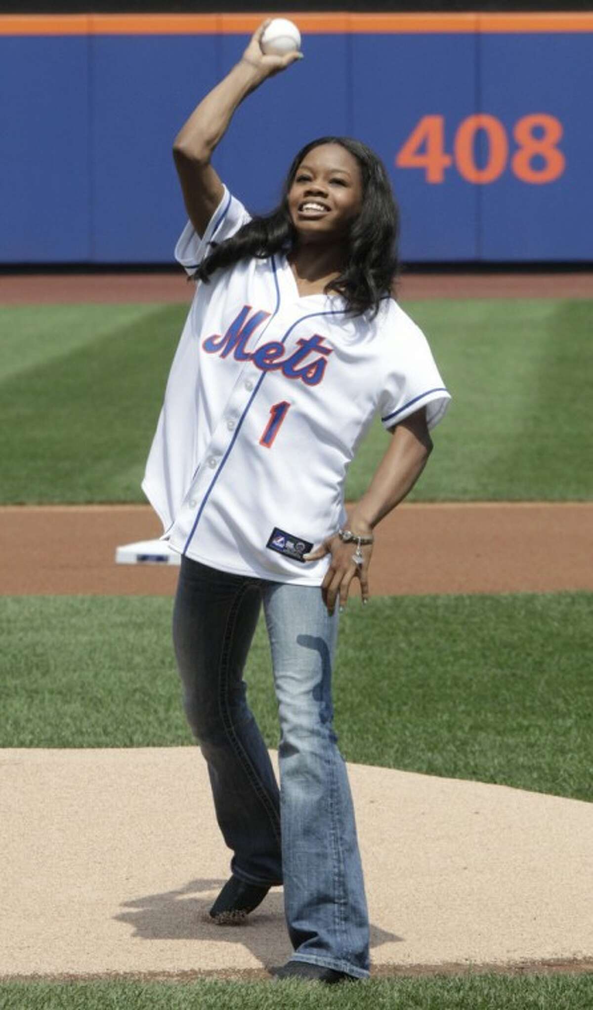Olympic gold medal gymnast Gabrielle Douglas throws out the ceremonial first pitch before a baseball game between the New York Mets and the Colorado Rockies, Thursday, Aug. 23, 2012, in New York. (AP Photo/Frank Franklin II)
