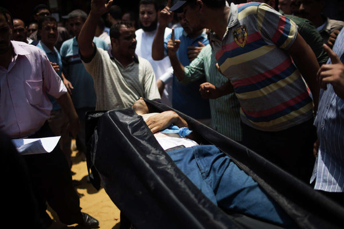 The corpse of a supporter for Egypt's ousted President Mohammed Morsi is brought to a morgue in Cairo, Egypt, Monday, July 8, 2013. Egyptian soldiers and police opened fire on supporters of the ousted president early Monday in violence that left dozens of people killed, including one officer, outside a military building in Cairo where demonstrators had been holding a sit-in, government officials and witnesses said. (AP Photo/Manu Brabo)