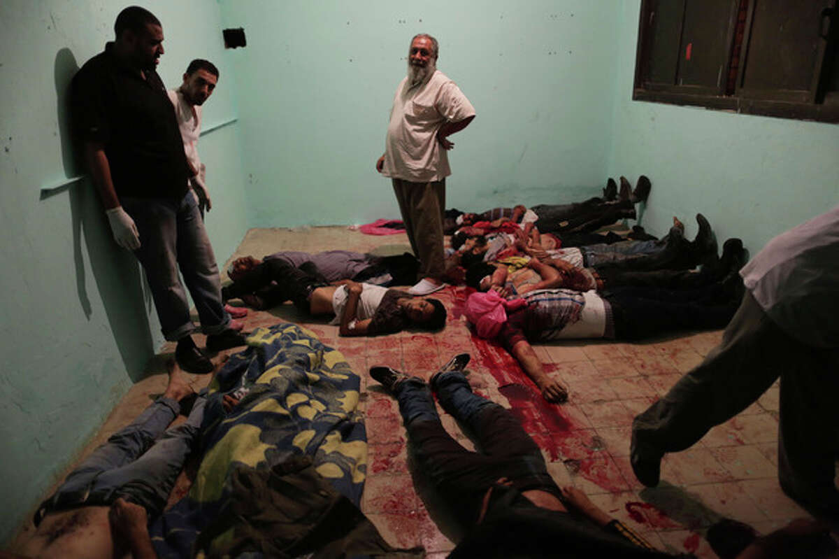 EDITOR'S NOTE: GRAPHIC CONTENT - Bodies lie in a room of a hospital after shooting happened at the Republican Guard building in Nasser City, Cairo, Monday, July 8, 2013. Egyptian soldiers and police opened fire on supporters of the ousted president early Monday in violence outside the military building in Cairo where demonstrators had been holding a sit-in, government officials and witnesses said. (AP Photo/Wissam Nassar)