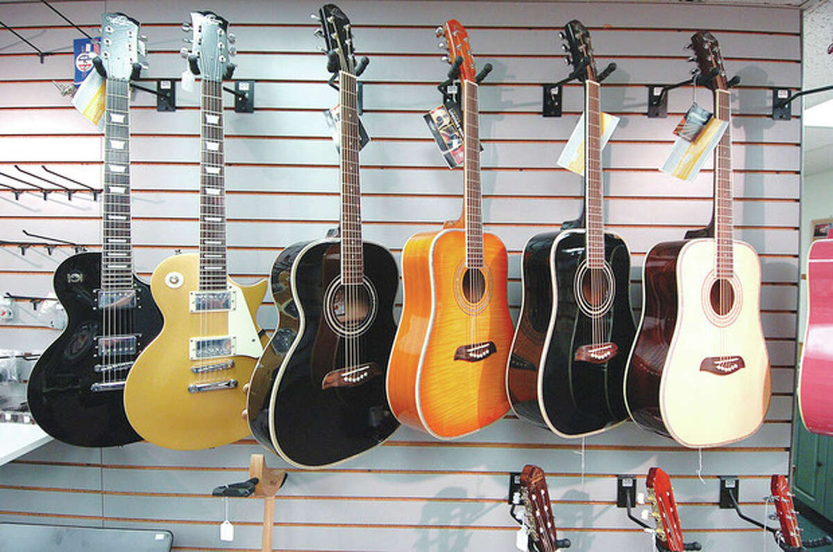 Hour Photo/ Alex von Kleydorff. Guitars for sale hang in the Westport Music Center