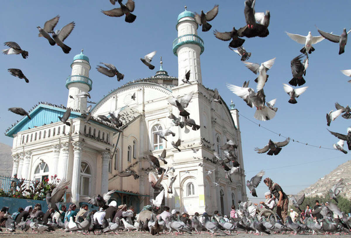 Pigeons fly outside Shah-e-Dushamshera's mosque where Afghans offer the Eid al-Fitr's prayers that marks the end of holy fasting month of Ramadan in Kabul, Afghanistan, Sunday, Aug. 19, 2012. (AP Photo/Musadeq Sadeq)