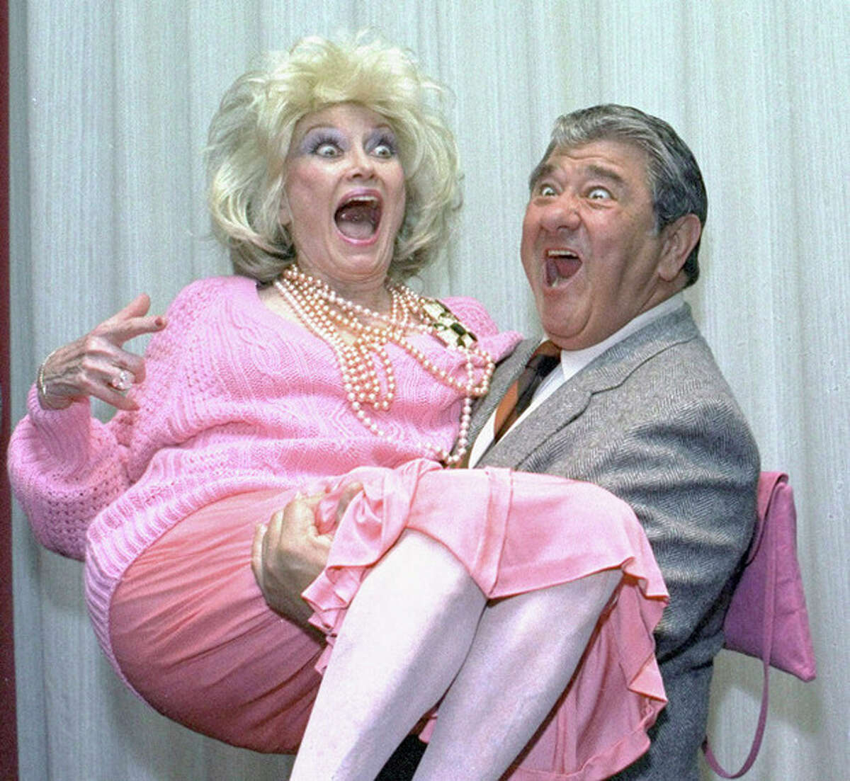 FILE-In this Oct. 9, 1985, file photo, Comedian Phyllis Diller gets a lift from emcee Buddy Hackett prior to the celebrity stag luncheon roast at the New York Friars Club in New York City. Diller, the housewife turned humorist who aimed some of her sharpest barbs at herself, died Monday, Aug. 20, 2012, at age 95 in Los Angeles.(AP Photo/Marty Lederhandler, File)