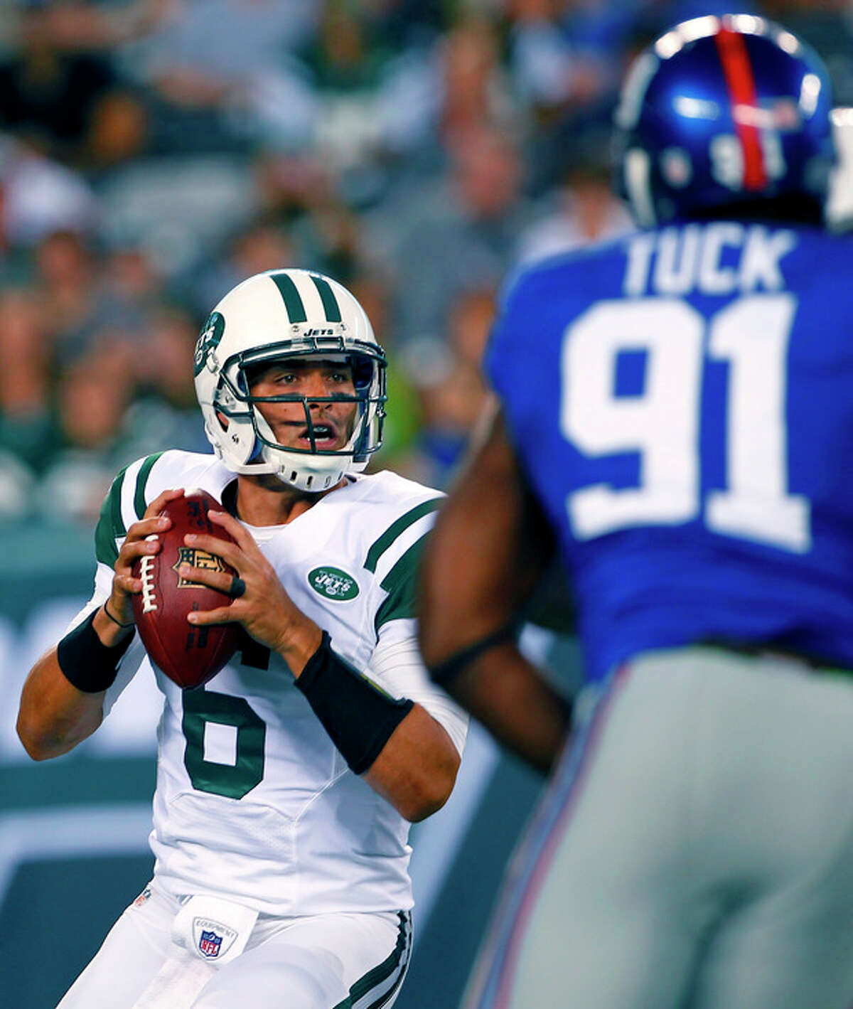New York Jets quarterback Mark Sanchez (6) passes under pressure from New York Giants defensive end Justin Tuck (91) during the first half of a preseason NFL football game on Saturday, Aug. 18, 2012, in East Rutherford, N.J. (AP Photo/Rich Schultz)
