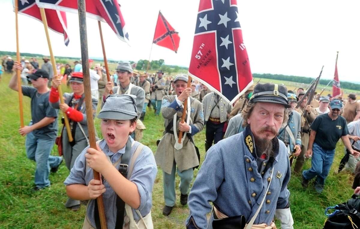 Paul Karabin, right, portraying Maj. Gen. George Pickett and Brodee Daniel, portraying Pickett's flag holder, participate in the Pickett's Charge commemorative march on Wednesday, July 3, 2013 during ongoing activities commemorating the 150th anniversary of the Battle of Gettysburg, Wednesday, July 3, 2013, in Gettysburg, Pa. (AP Photo/York Daily Record, Jason Plotkin)