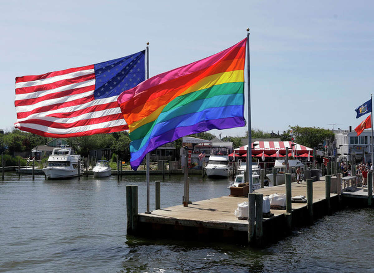 AP Photo/Seth Wenig In this June 23, photo, an American flag and a LGBT Rainbow flag are displayed on the ferry dock in the Fire Island community of Cherry Grove, N.Y.