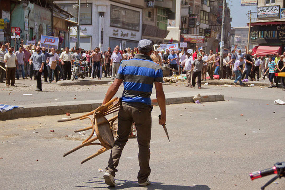 An Egyptian opposition protester holds a chair and knife during a clash between supporters and opponents of President Mohammed Morsi in downtown Damietta, Egypt, Wednesday, July 3, 2013. The deadline on the military's ultimatum to President Mohammed Morsi has expired, with 48 hours passing since the time it was issued. Giant cheering crowds of Morsi's opponents have been gathered in Cairo's Tahrir Square and other locations nationwide, waving flags furiously in expection that the military will act to remove the Islamist president after the deadline ends.(AP Photo/Hamada Elrasam)