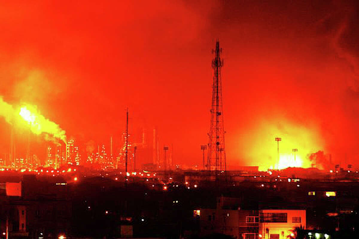 Fire rises over Amuay refinery near Punto Fijo, Venezuela, Saturday, Aug. 25, 2012. A huge explosion rocked Venezuela's biggest oil refinery, killing at least 19 people and injuring dozens, an official said. (AP Photo/Daniela Primera)