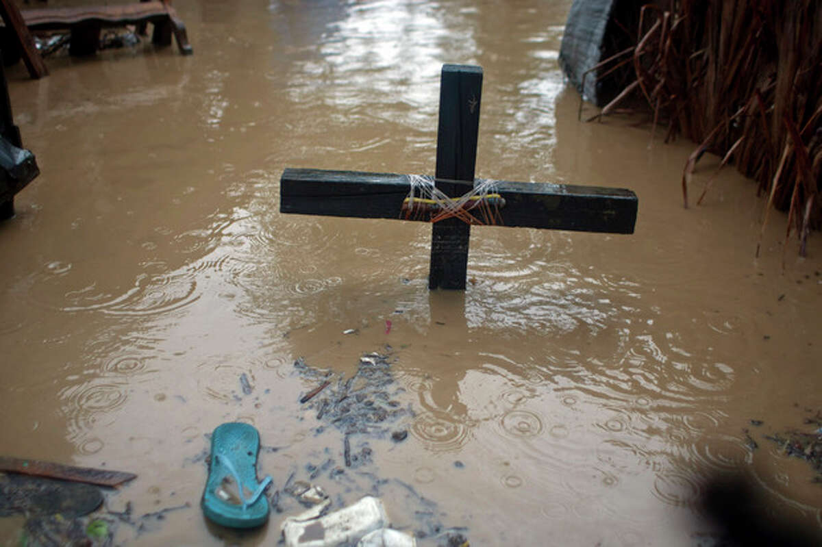 A voodoo cross in honor of the Baron Samedi stands in floodwaters, triggered by Tropical Storm Isaac, at a place of worship in Port-au-Prince, Haiti, Saturday, Aug. 25, 2012. Tropical Storm Isaac swept across Haiti's southern peninsula early Saturday, dousing a capital city prone to flooding and adding to the misery of a poor nation still trying to recover from the 2010 earthquake. (AP Photo/Dieu Nalio Chery)