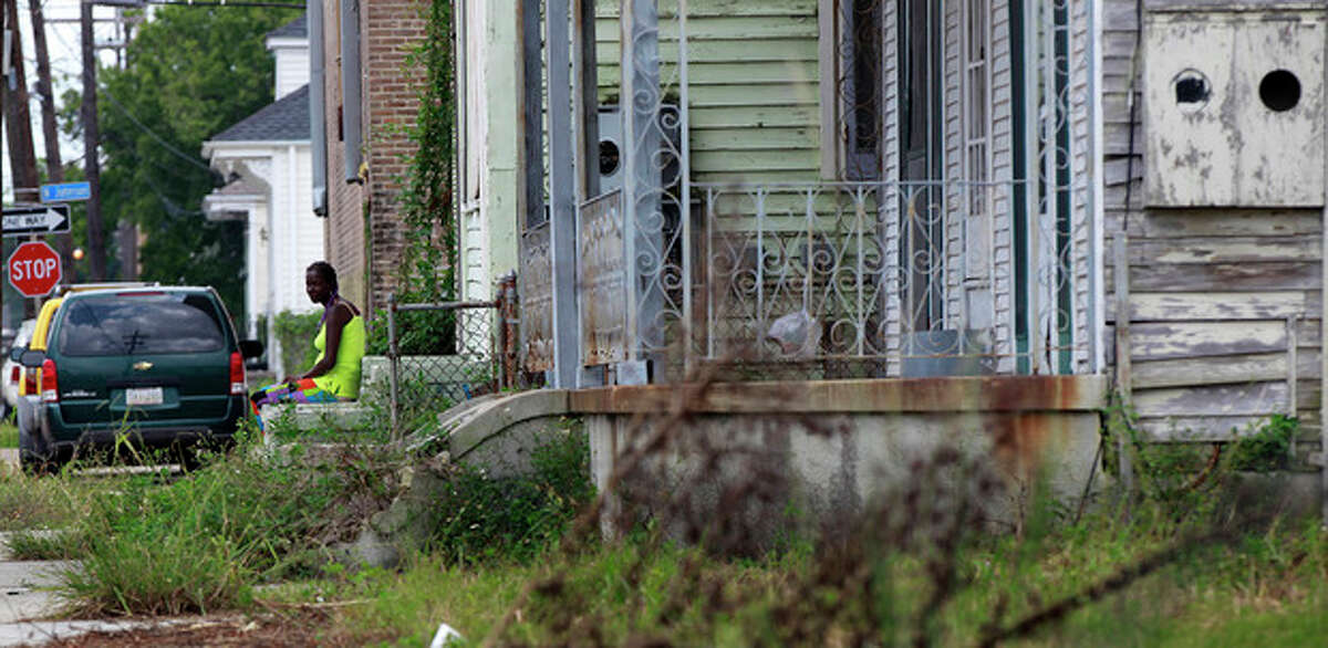 A woman sits on a stoop on St. Ann St. in the Treme section of New Orleans, Thursday, Aug. 23, 2012. The face of New Orleans is changing: Seven years after Hurricane Katrina the city many said would not recover is racially more diverse, and whiter, younger and richer; indicators not of failure but its success at reinventing itself. In fact, the city is experiencing a boom, and even gentrifying.(AP Photo/Gerald Herbert)