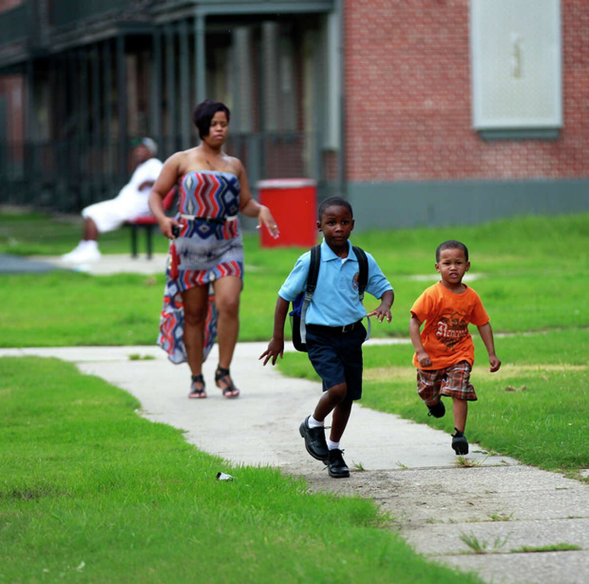 Children run in a courtyard of the Iberville housing projects, slated to be torn down, in New Orleans, Thursday, Aug. 23, 2012. The face of New Orleans is changing: Seven years after Hurricane Katrina the city many said would not recover is racially more diverse, and whiter, younger and richer; indicators not of failure but its success at reinventing itself. In fact, the city is experiencing a boom, and even gentrifying.(AP Photo/Gerald Herbert)
