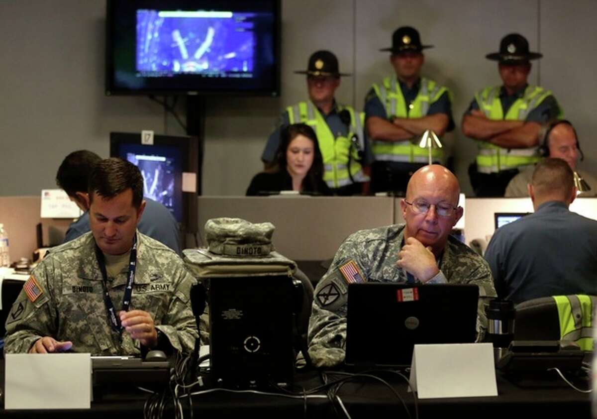 Law enforcement officials monitor surveillance cameras as part of an increased security effort for the Independence Day celebration, the first major public gathering since the Boston Marathon bombings, at the Unified Command Center, Wednesday, July 3, 2013, in Boston. The temporary command center combines the control and management of security by local, state and federal law enforcement officals in one location. (AP Photo/Charles Krupa)