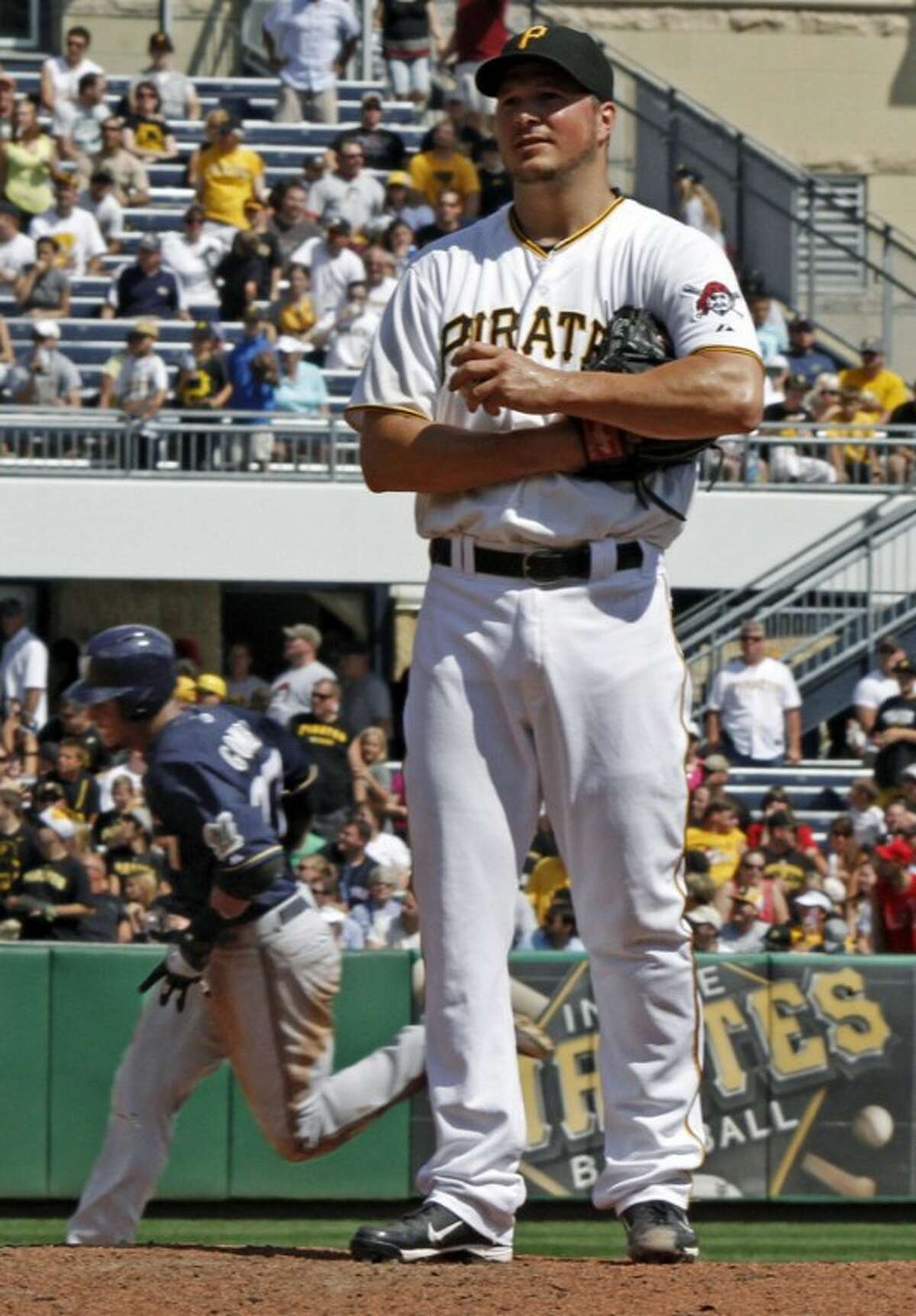 Pittsburgh Pirates starting pitcher Erik Bedard, right, stands on the mound as Milwaukee Brewers' Carlos Gomez rounds the bases behind him after hitting a three-run home run in the fourth inning of a baseball game, Sunday, Aug. 26, 2012, in Pittsburgh. (AP Photo/Keith Srakocic)