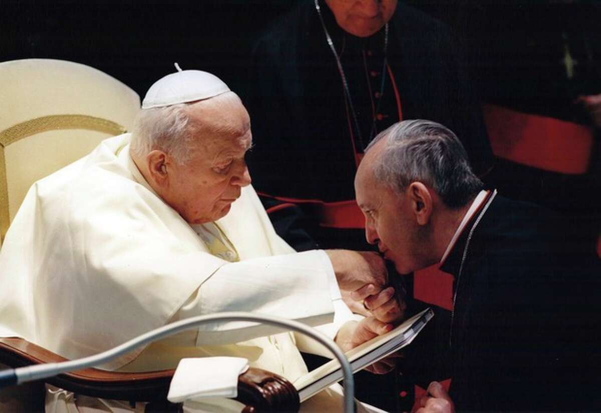 FILE - In this undated picture released by Sergio Rubin, Jorge Mario Bergoglio, Archbishop of Buenos Aires, right, kisses the hand of Pope John Paul II during a ceremony at the Vatican. Bergoglio, who became Pope Francis on Wednesday, March 13, 2013, cleared Pope John Paul II for sainthood, approving a miracle attributed to his intercession and setting up a remarkable dual canonization along with another beloved pope, John XXIII. (AP Photo/Sergio Rubin)