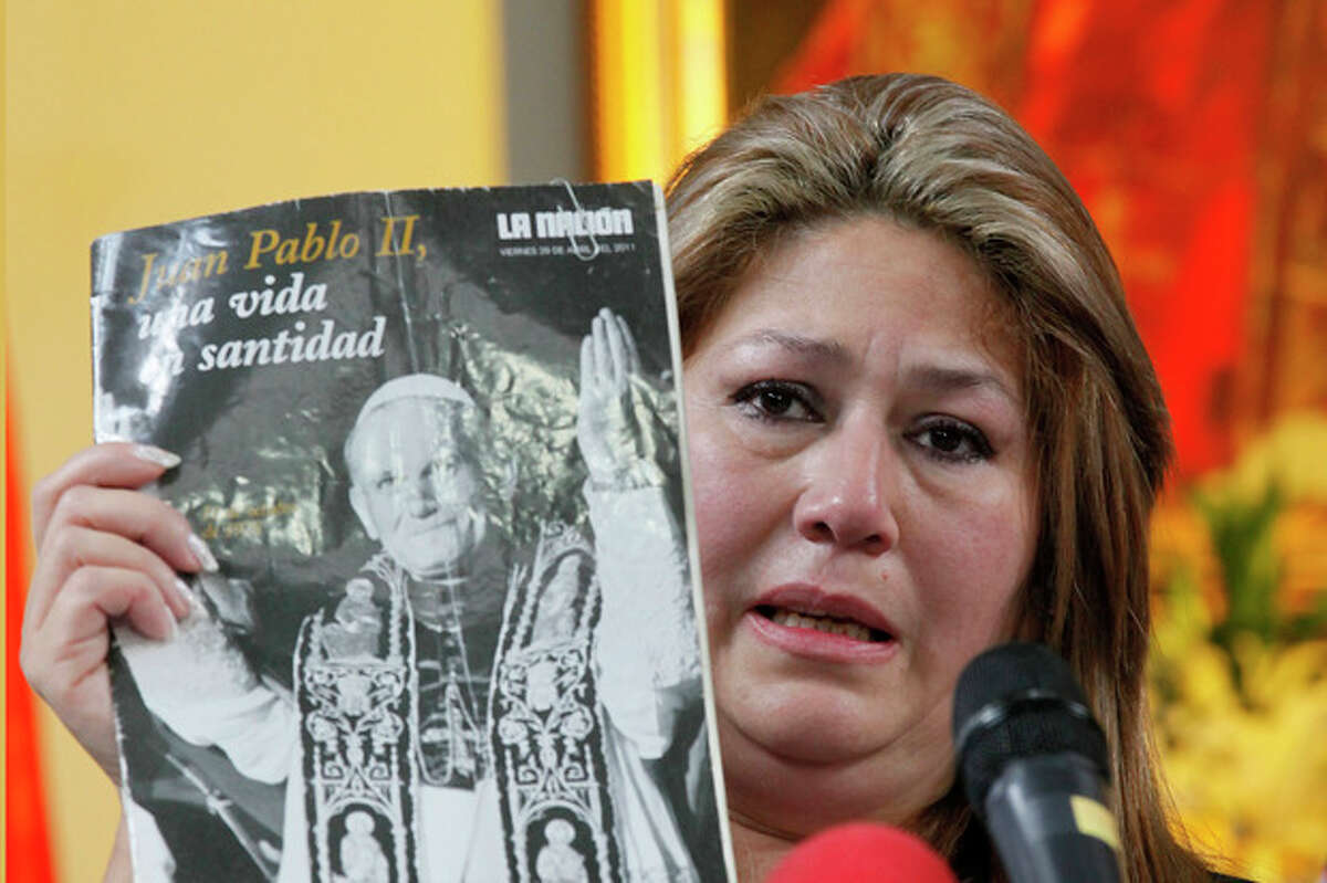 Costa Rica Floribeth Mora holds up a magazine featuring Pope John Paul II on the cover, as she gives her account of a miracle attributed to John Paul, during a press conference, at the Archbishop's office in San Jose, Costa Rica, Friday, July 5, 2013. Pope Francis on Friday approved the miracle of the Costa Rican woman bringing John Paul to the ranks of saints. Mora suffering from a cerebral aneurism and only given a month to live, was inexplicably cured on May 1, 2011, the date of John Paul's beatification, when millions of worshippers filled St. Peter's Square to honor the beloved Polish pontiff. (AP Photo/Enrigue Martinez)