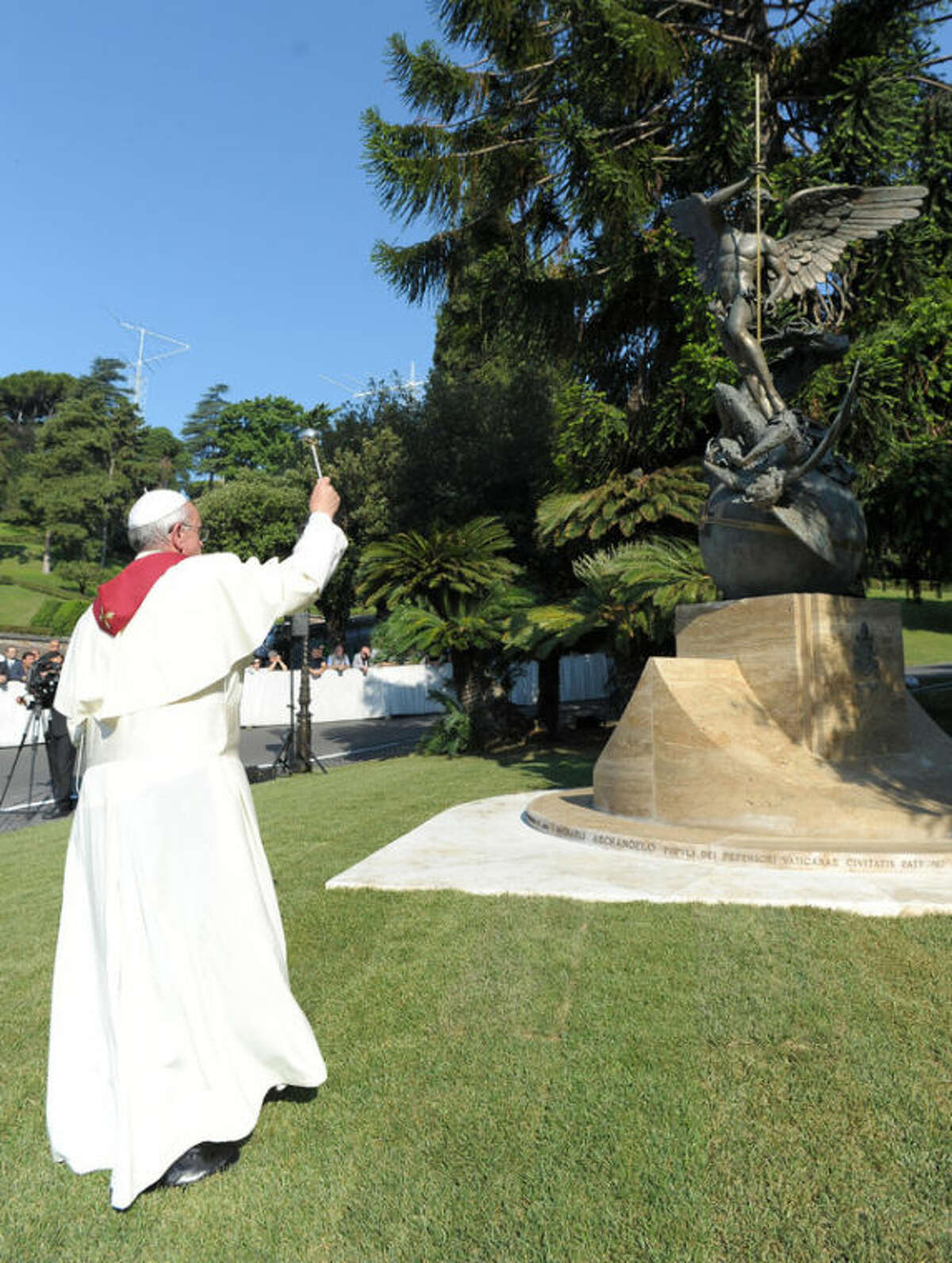 In this photo provided by the Vatican newspaper L'Osservatore Romano Pope Francis blesses the San Michele Arcangelo statue during a ceremony for its unveiling at the Vatican, Friday, July 5, 2013. Francis and Pope emeritus Benedict XVI were together Friday morning for the inauguration of the new monument inside the Vatican gardens - the first time they have been seen together since May 2, when Francis welcomed Benedict back to the Vatican after his initial retirement getaway. Pope Francis issued his first encyclical Friday, a meditation on faith that is unique because it was written with Benedict XVI. Benedict's hand is evident throughout much of the first three chapters of "The Light of Faith," with his theological style, concerns and reference points clear. (AP Photo/L'Osservatore Romano, ho)