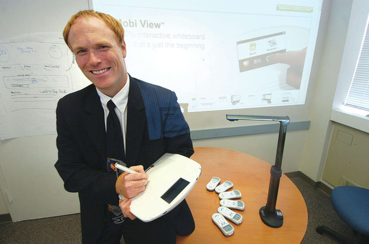 Hour photo / Alex von Kleydorff Robert Polselli Jr., director of Technology for Norwalk Public Schools, holds the Mobi unit. Next to him are the CPS Clickers and the Hoover cam.