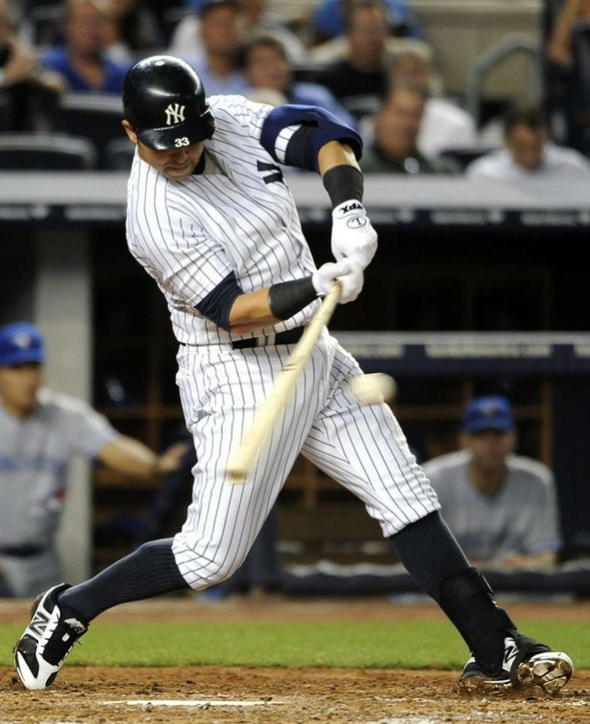 New York Yankees' Nick Swisher hits an RBI single off of Toronto Blue Jays starting pitcher Ricky Romero in the third inning of a baseball game on Tuesday, Aug., 28, 2012, in New York. (AP Photo/Kathy Kmonicek)