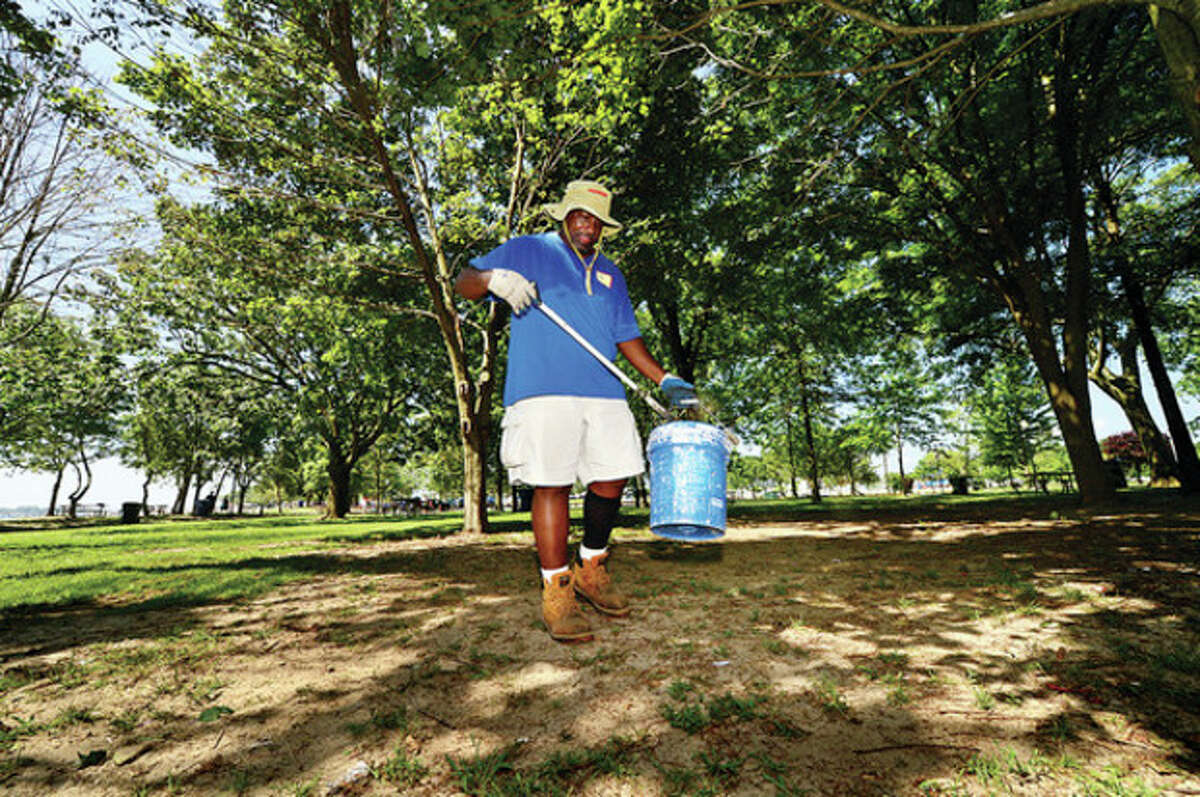 Recreation and Parks worker Al Howard picks up bits of trash at Shady Beach Friday following the independence Day holiday. Last year there were complaints about the Recreation and Parks Department slow respose to trash clean up.Hour photo / Erik Trautmann