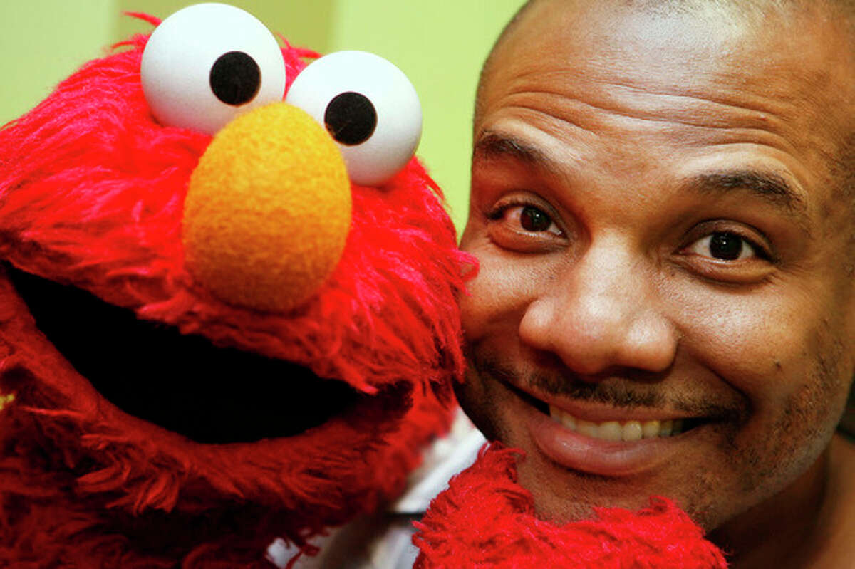 FILE - This Aug 16, 2006 file photo shows Kevin Clash, who was the voice and movements behind Sesame Street's Elmo, posing for a picture with Elmo in New York. Three lawsuits brought by men who said Clash sexually abused them when they were underage were tossed out by a federal judge who said in a decision published Monday, July 1, 2013, that the men waited too long to sue. (AP Photo/Seth Wenig, File)