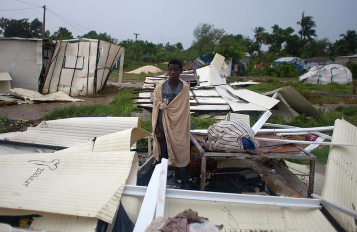 A man stands next to his bed after Tropical Storm Isaac destroyed his home and others at a camp set up for people displaced by the 2010 earthquake in Port-au-Prince, Haiti, Saturday, Aug. 25, 2012. Tropical Storm Isaac swept across Haiti's southern peninsula early Saturday, dousing a capital city prone to flooding and adding to the misery of a poor nation still trying to recover from the 2010 earthquake. (AP Photo/Dieu Nalio Chery)