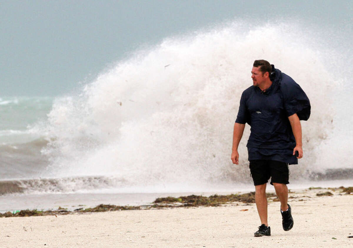 A man walks on the beach in Key West, Fla., Sunday, Aug. 26, 2012 as heavy winds hit the northern coast from Tropical Storm Isaac. Isaac is expected to continue streaming across Marion County Monday as it continues toward the northern Gulf of Mexico. National Weather Service officials in Jacksonville on Sunday said Marion County began getting rain bands from Isaac around 2 p.m. and that the rain would continue through Tuesday. (AP Photo/Alan Diaz)